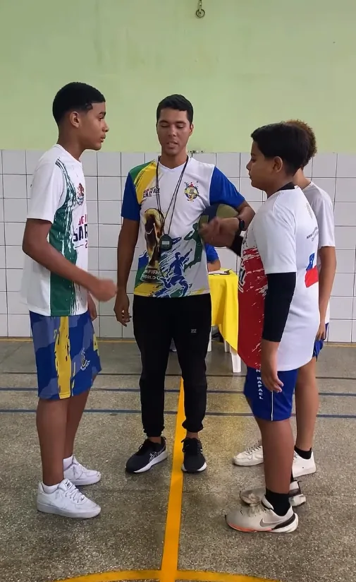Professor apitando o início de uma partida dos jogos internos na quadra do colégio