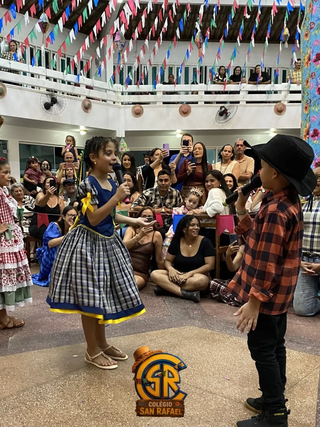 Alunos dançando quadrilha para as famílias no pátio